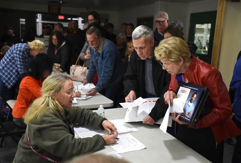Voters register during a Republican caucus event at Hug High School in Reno