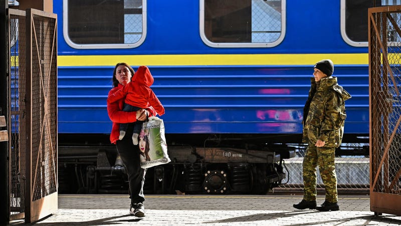 A woman with a child in her arms arrives in Poland via train after fleeing war-torn Ukraine
