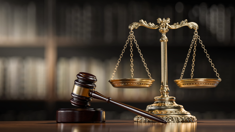 Scales of justice and a judge's gavel hammer as a symbol of law and order.