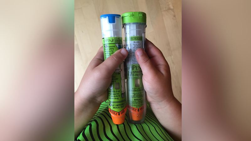 Child holding two EpiPens. 