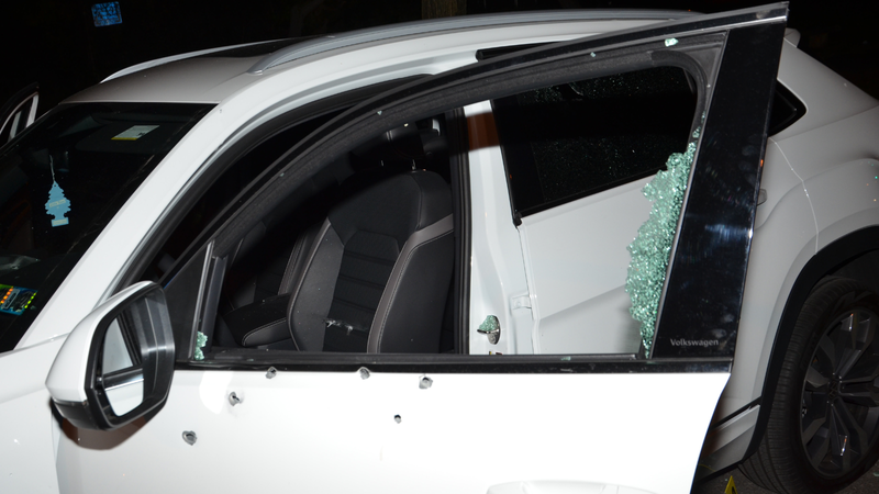 Bullet holes in the side of a car; window completely shattered.