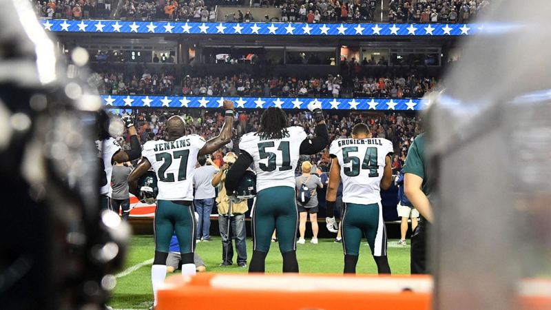 Philadelphia Eagles strong safety Malcolm Jenkins (27) and defensive end Steven Means (51) raise their right hands up during the playing of the national anthem prior to the game against the Chicago Bears at Soldier Field.