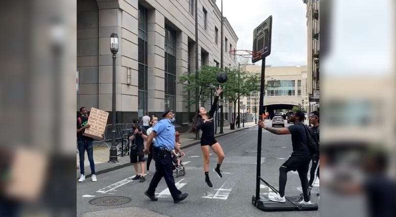 Stephania Ergemlidze playing basketball with a police officer