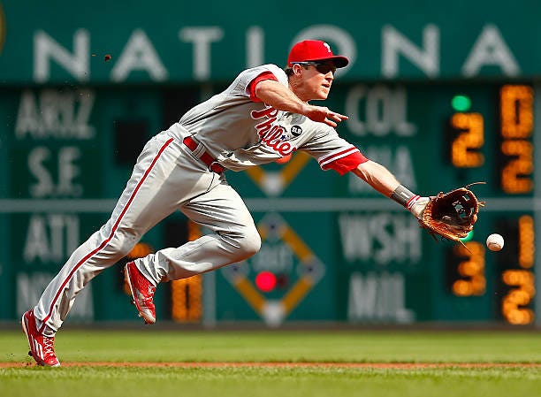 June 13, 2015: Chase Utley of the Phillies flips the ball to first base against the Pirates in Pittsburgh, Pennsylvania.