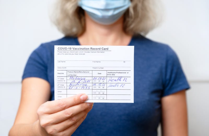 A woman shows her Covid-19 vaccine card