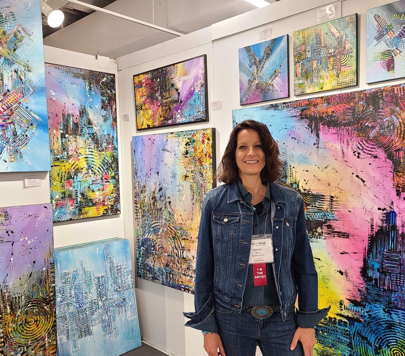 Artist showing off her layered paintings
