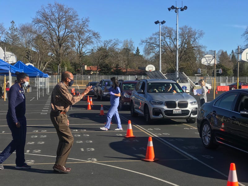 A local doctor sets up a drive-thru COVID-19 vaccine clinic at a Lafayette middle school.