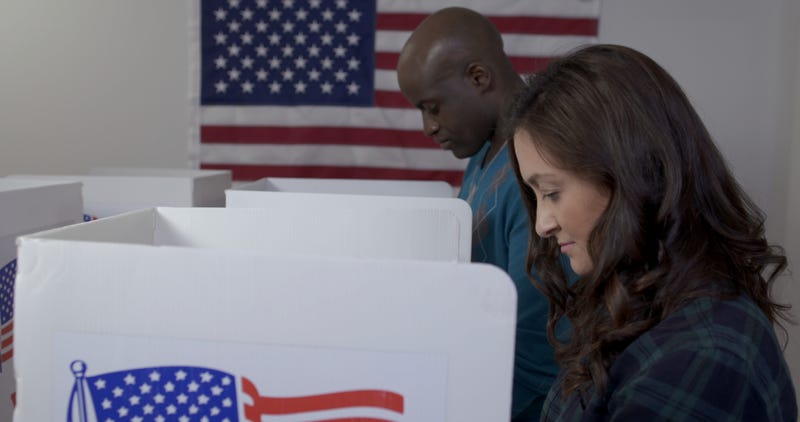 A woman and a man cast their ballots