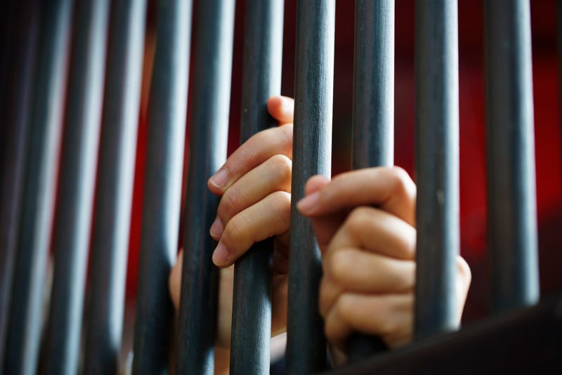 Hands on bars in prison.