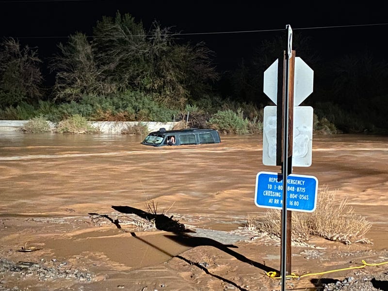 A vehicle is stuck on a flooded road near Moapa