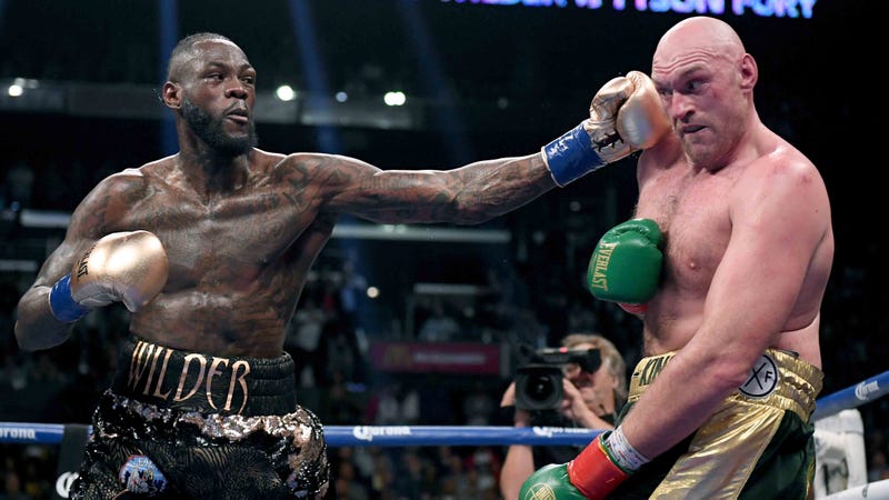 Deontay Wilder delivers a left hook to Tyson Fury during their heavyweight title boxing match in December 2018.