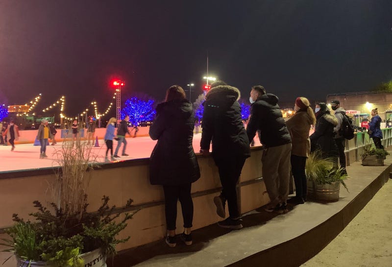Patrons look on as skaters enjoy the ice at Winterfest on Penn's Landing.