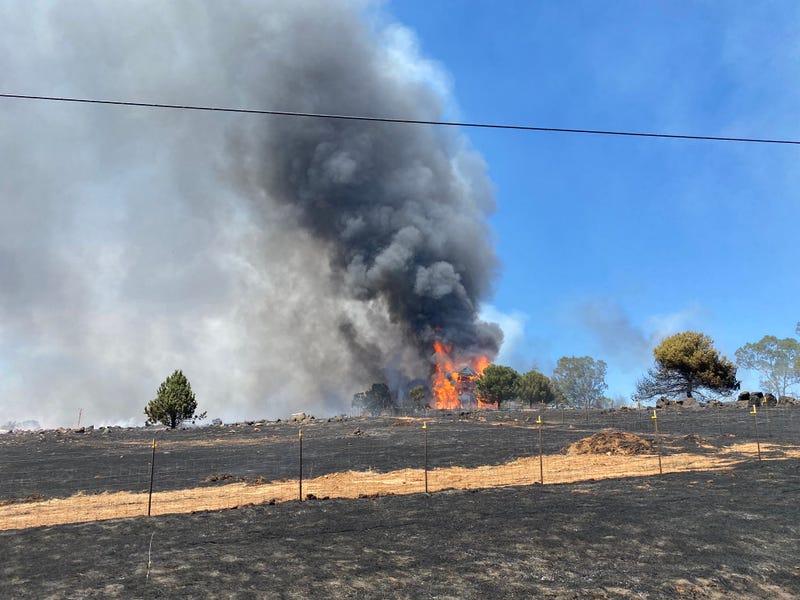 Multiple structures are threatened by a grass fire in Yuba County late Tuesday.