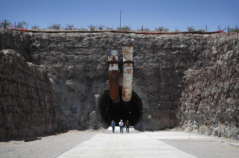 People leave the south portal of Yucca Mountain during a congressional tour on July 14, 2018, near Mercury, Nev.
