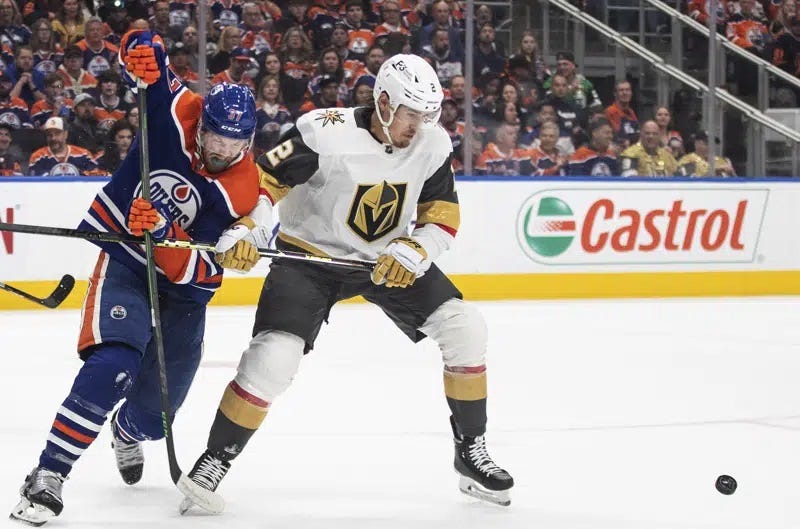 Vegas Golden Knights' Zach Whitecloud (2) and Edmonton Oilers' Warren Foegele (37) battle for the puck