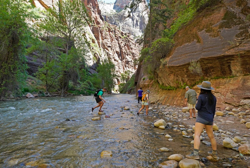 Hikers take pictures at the entrance of the famous Narrows hike, currently closed, along the North Fork of the Virgin River in Zion National Park on May 15, 2020 in Springdale, Utah.