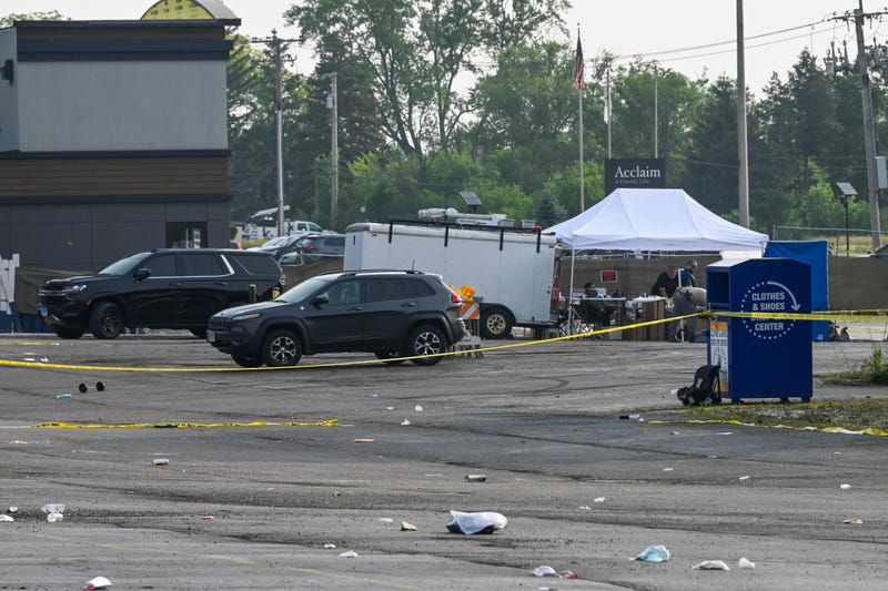 Investigators look over the scene of an overnight mass shooting at a strip mall in suburban Chicago, Sunday, June 18, 2023.