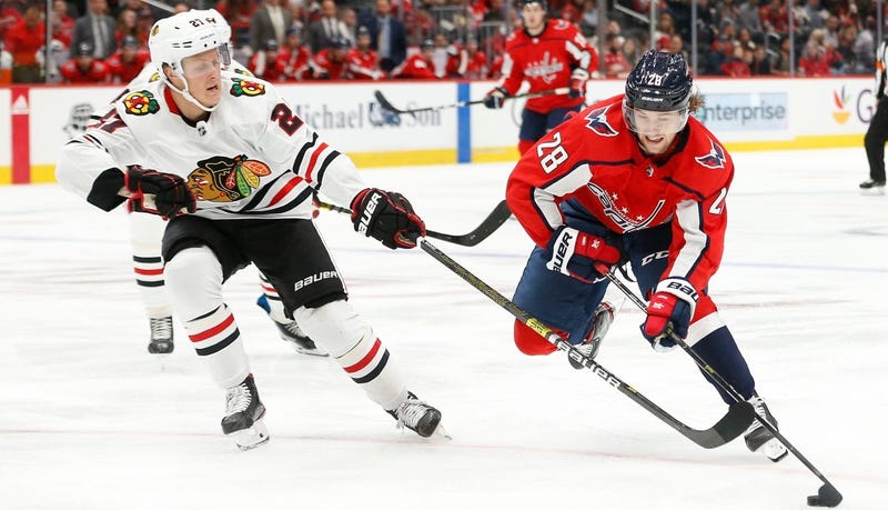Blackhawks defenseman Adam Boqvist, left, defends against Capitals winger Brendan Leipsic (28).