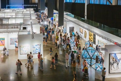 Art Fairgoers wandering around inside the huge show at Lumen Field Event Center