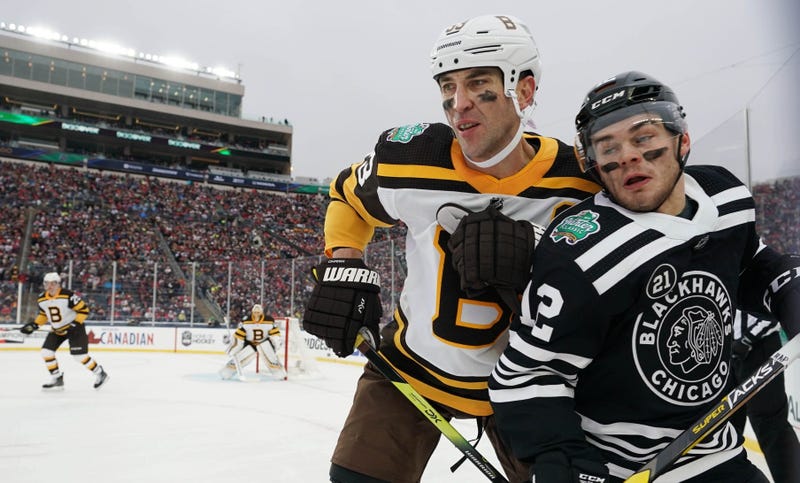 ruins defenseman Zdeno Chara (33) checks Blackhawks winger Alex DeBrincat (12).