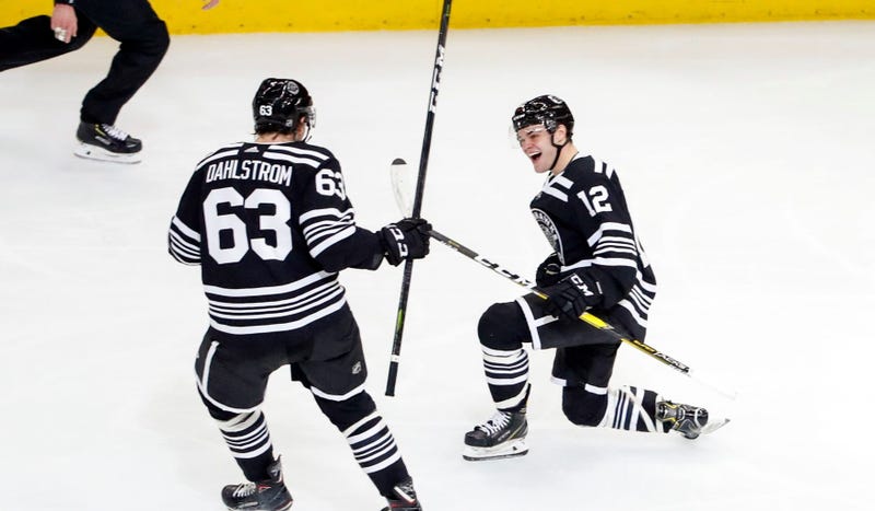 Blackhawks winger Alex DeBrincat (12) celebrates with defenseman Carl Dahlstrom (63) after scoring a goal.