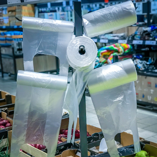Plastic cellophane bags hanging on the stand in the supermarket fruits - vegetables department.