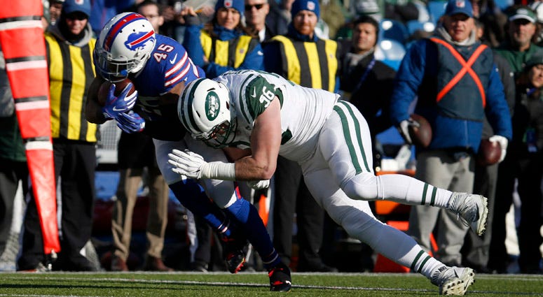 New York Jets defensive end Henry Anderson (96) tackles Buffalo Bills running back Marcus Murphy (45) as he runs the ball during the first half at New Era Field.