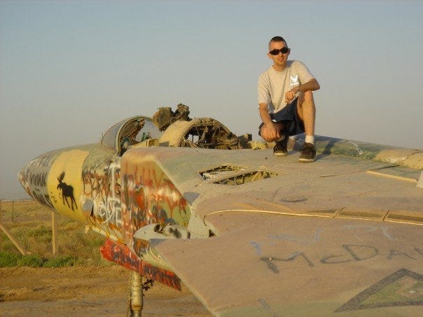 Blad Air Base Andrew Koehle sits atop a derelict Russian MiG fighter