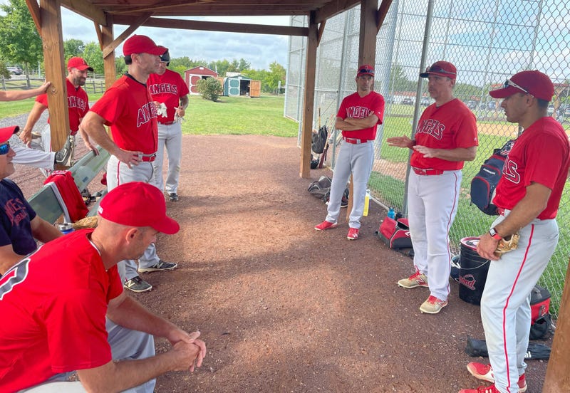 The Northampton Angels of the Bux-Mont Senior Men's Baseball League confer in the dugout.