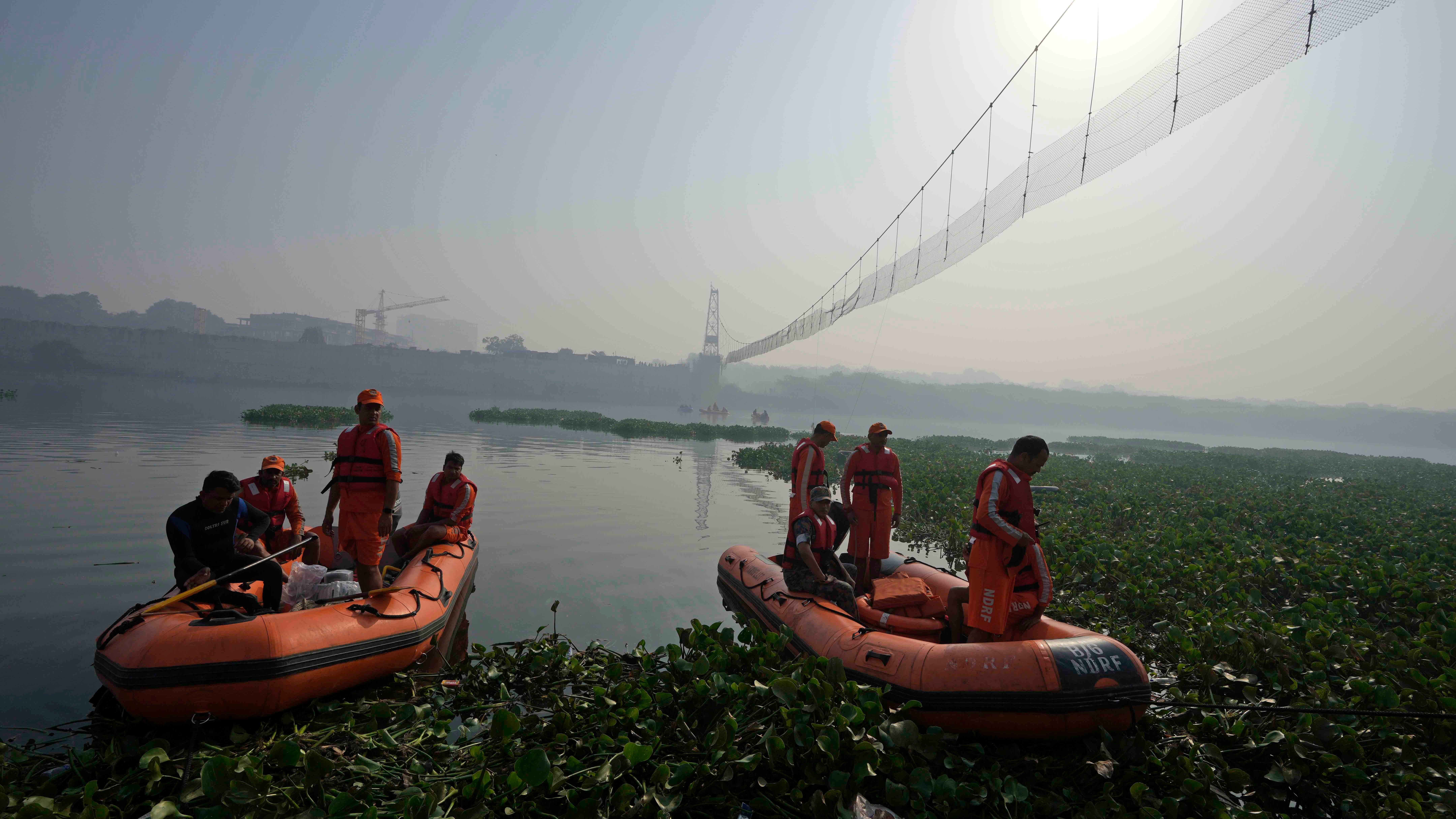 Officials probe India bridge collapse as divers comb river