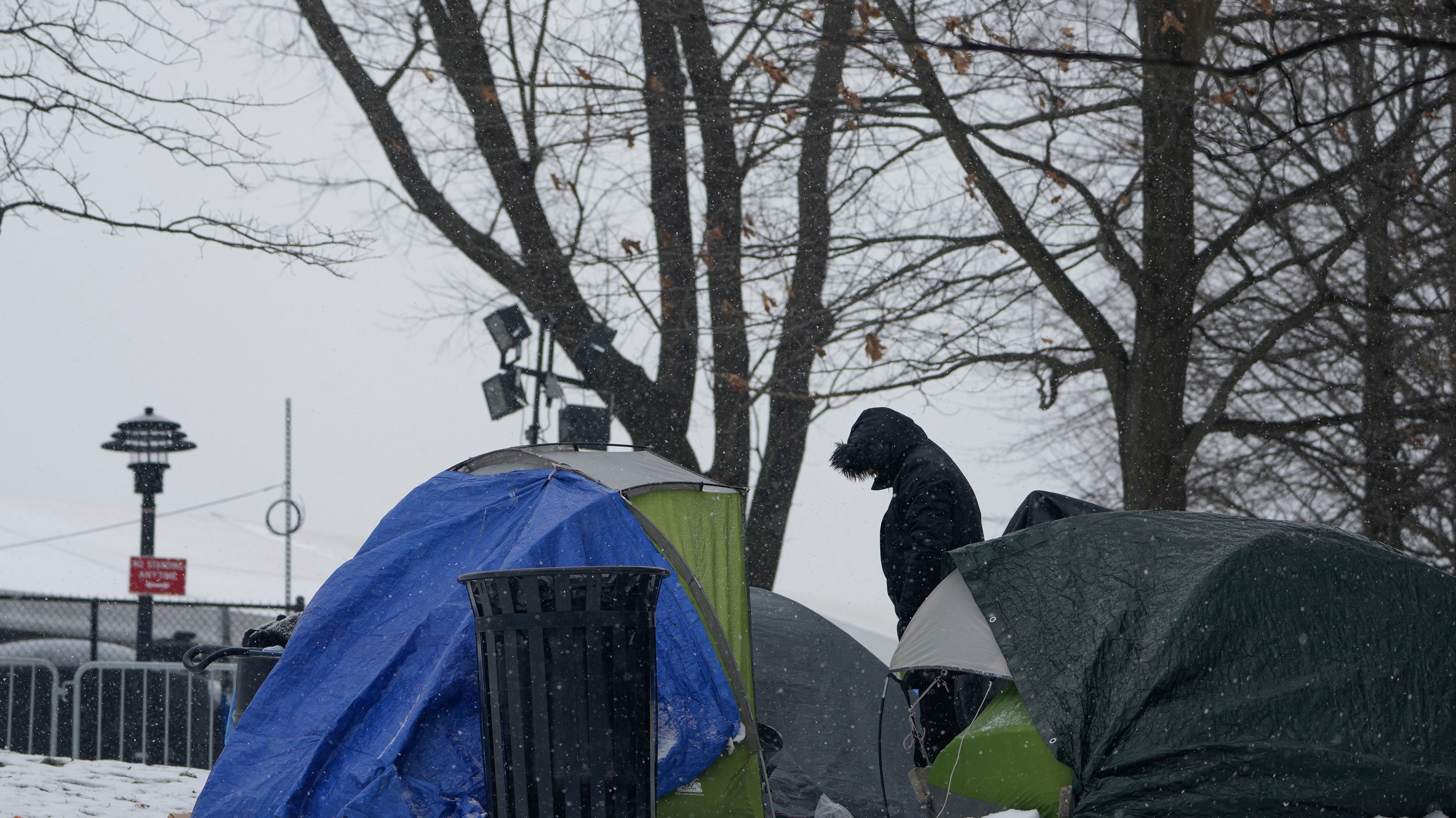 Ante escasez de camas y bajas temperaturas, migrantes colocan campamento frente a albergue de NY
