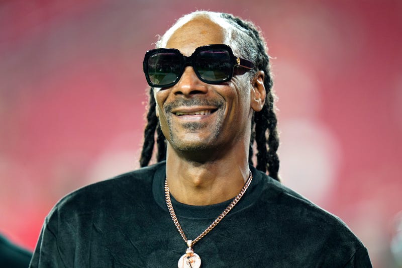 FILE - Entertainer Snoop Dogg walks on the field before an NFL football game between the Tampa Bay Buccaneers and the New Orleans Saints Sunday, Dec. 19, 2021, in Tampa, Fla. Snoop Dogg says he won’t let the big Super Bowl stage rattle his nerves. The ultra-smooth rapper said he will worry about his upcoming halftime performance after the fact. He’ll take the stage with Dr. Dre, Eminem, Kendrick Lamar and Mary J. Blige during Super Bowl 56 on Sunday, Feb. 13, 2022. (AP Photo/Chris O'Meara, File)