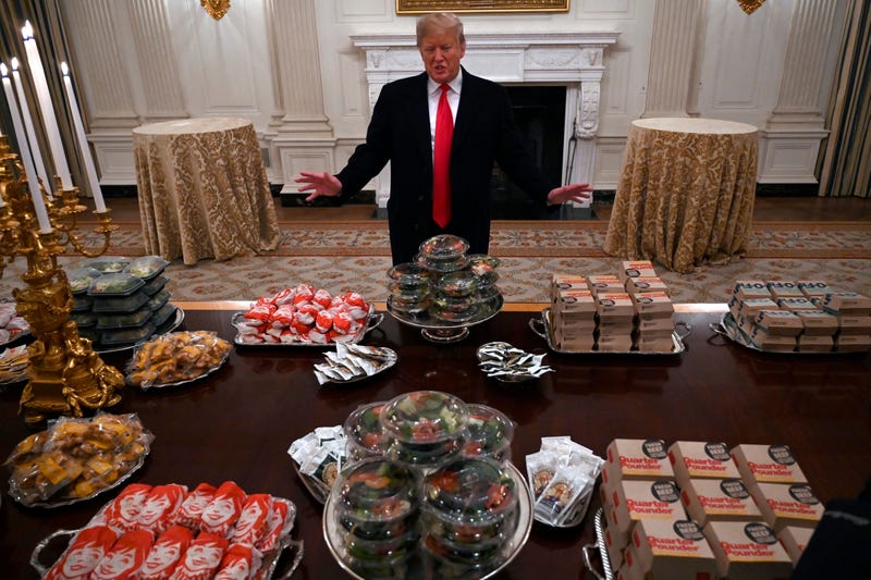 President Donald Trump talks to the media about the table full of fast food in the State Dining Room of the White House