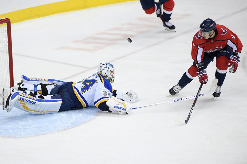 Washington Capitals defenseman Dmitry Orlov (9), of Russia, and St. Louis Blues goaltender Jake Allen (34) fight for the puck