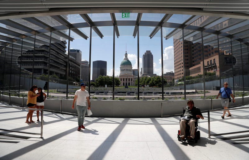 In this June 20, 2018, file photo, visitors use a new entrance to the Gateway Arch as the Old Courthouse and the rest of downtown are seen through its windows in St. Louis.