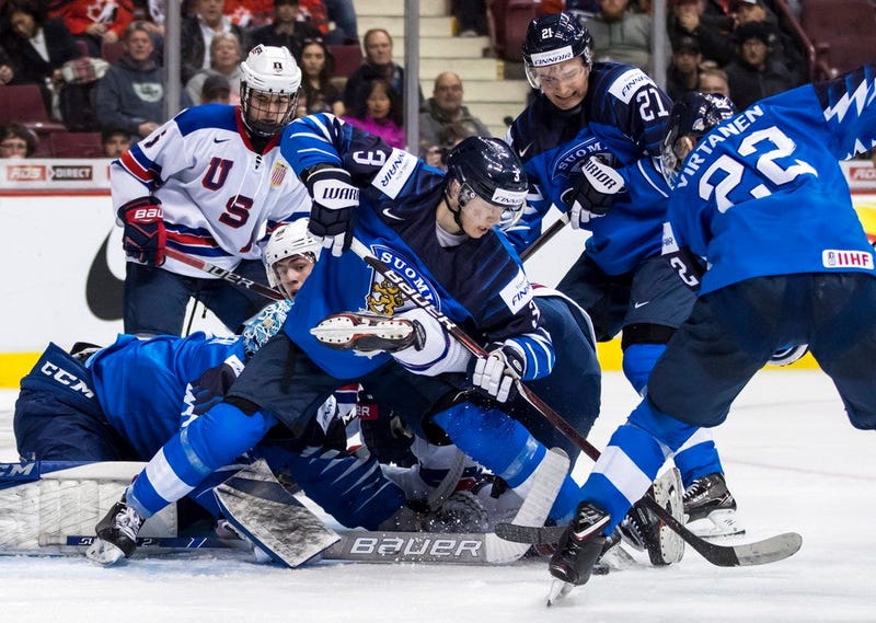 Finland goalie Ukko-Pekka Luukkonen, left, stops United States' Noah Cates