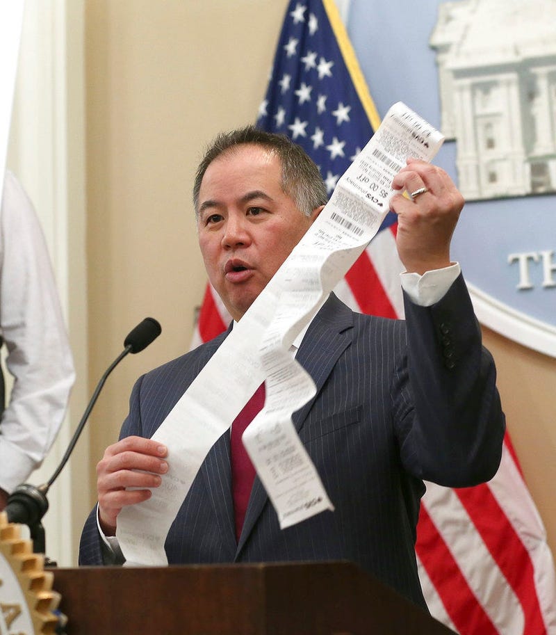 Assemblyman Phil Ting, D-San Francisco, displays a long paper receipt