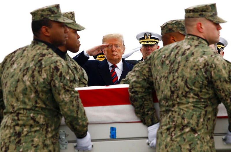 President Donald Trump salutes as a U.S. Navy carry team moves a transfer case containing the remains of Scott A. Wirtz, Saturday, Jan. 19, 2019, at Dover Air Force Base, Del