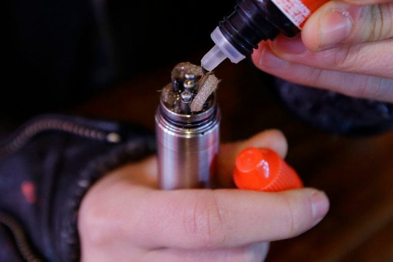 a liquid nicotine solution is poured into a vaping device at a store in New York