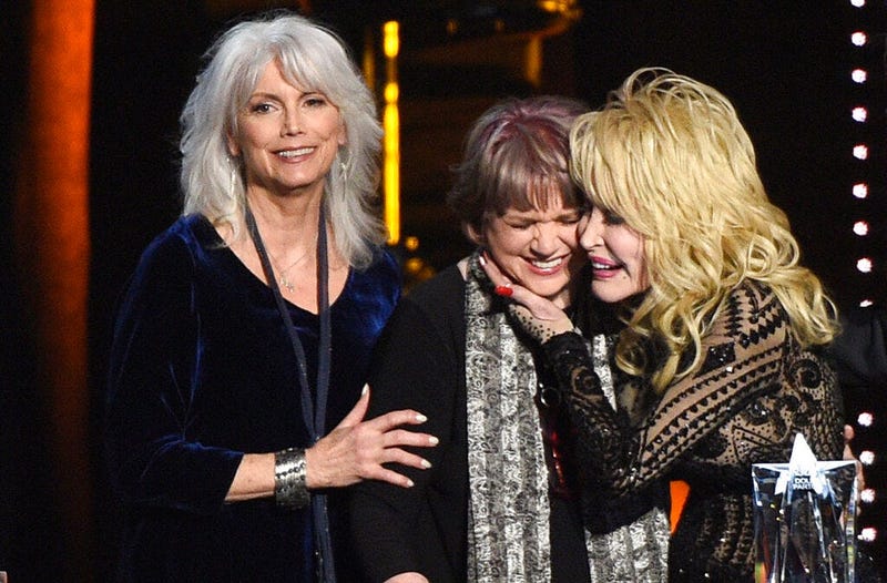 Emmylou Harris, from left, and Linda Ronstadt present Dolly Parton with the MusiCares Person of the Year award on Friday, Feb. 8, 2018