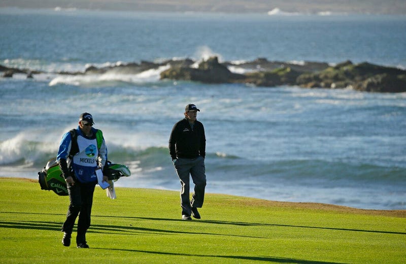 Phil Mickelson walks up the 18th fairway of the Pebble Beach Golf Links with his brother and caddie Tim Mickelson during the final round of the AT&T Pebble Beach Pro-Am golf tournament Monday, Feb. 11, 2019, in Pebble Beach, Calif.