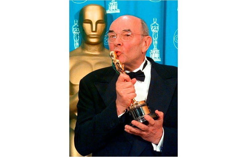 director Stanley Donen kisses the Oscar he received for Lifetime Achievement backstage at the 70th Academy Awards