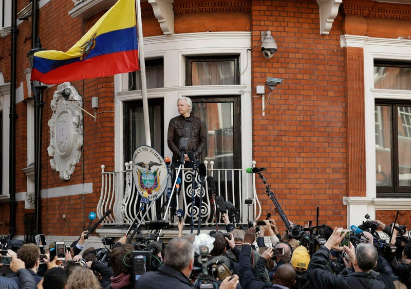 In this file photo dated Friday May 19, 2017, watched by the media WikiLeaks founder Julian Assange looks out from the balcony of the Ecuadorian embassy prior to speaking, in London.