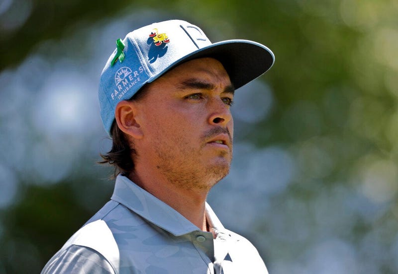 Rickie Fowler wears a green ribbon in support of the victims of the shooting at the University of North Carolina-Charlotte as he walks from the first tee during the first round of the Wells Fargo Championship golf tournament at Quail Hollow Club in Charlo