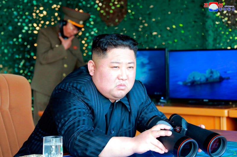 North Korean leader Kim Jong Un, equipped with binoculars, observing tests of different weapons systems, in North Korea