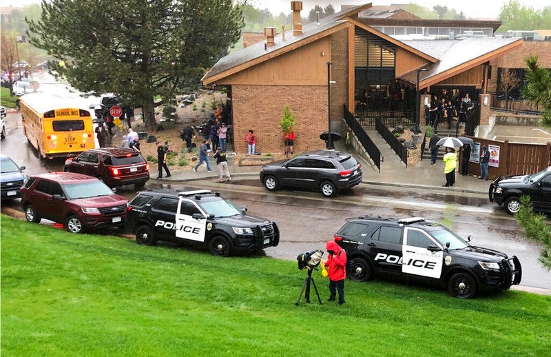Police and others are seen outside STEM School Highlands Ranch, a charter middle school in the Denver suburb of Highlands Ranch, Colo., after a shooting Tuesday, May 7, 2019. Authorities said several people were injured and a few suspects were in custody.