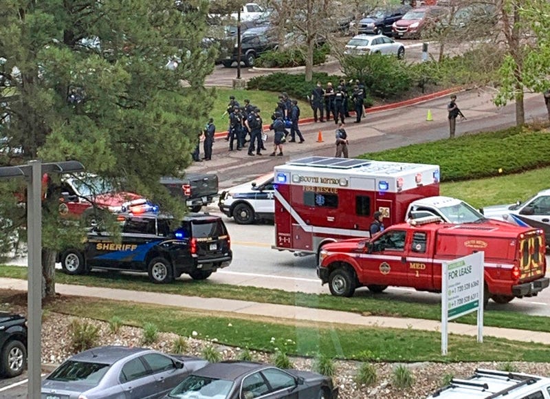 Armed police officers and others are seen outside STEM School Highlands Ranch, a charter middle school in the Denver suburb of Highlands Ranch, Colo., after a shooting Tuesday, May 7, 2019.