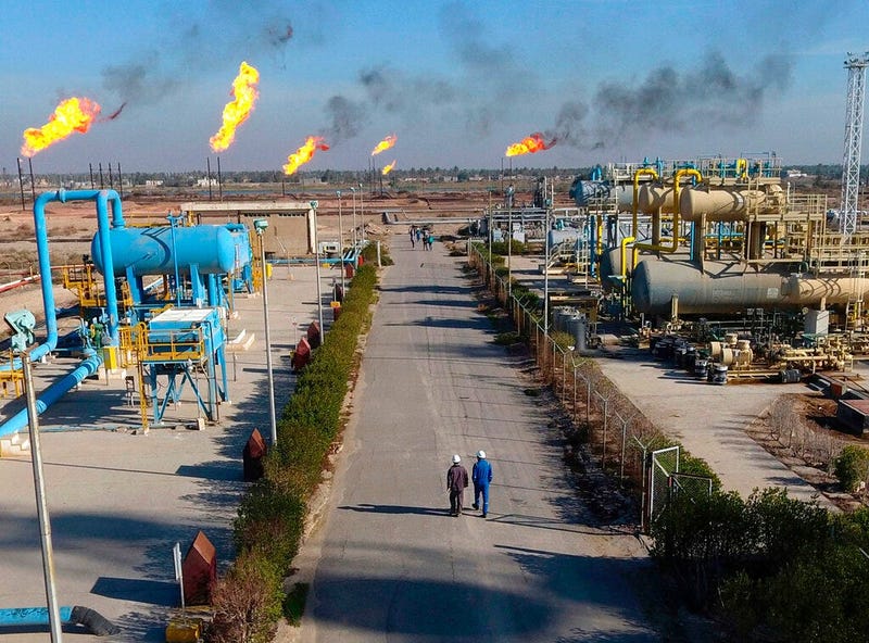 workers walk in the Nihran Bin Omar field north near Basra, Iraq. An Iraqi oil official says employees of energy giant Exxon Mobil have started evacuating an oil field in the southern province of Basra, amid rising tensions between the United States and I