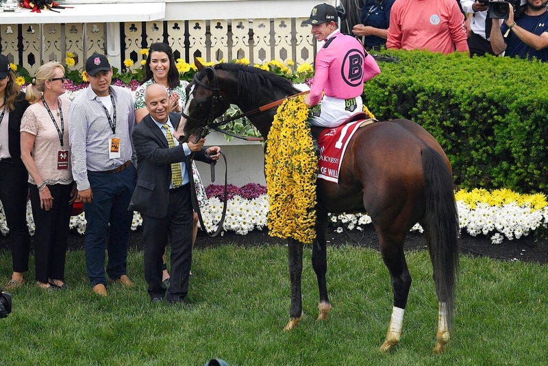Jockey Tyler Gaffalione sits aboard War of Will as trainer Mark Casse holds the reins after winning the Preakness Stakes horse race at Pimlico Race Course, Saturday, May 18, 2019, in Baltimore.