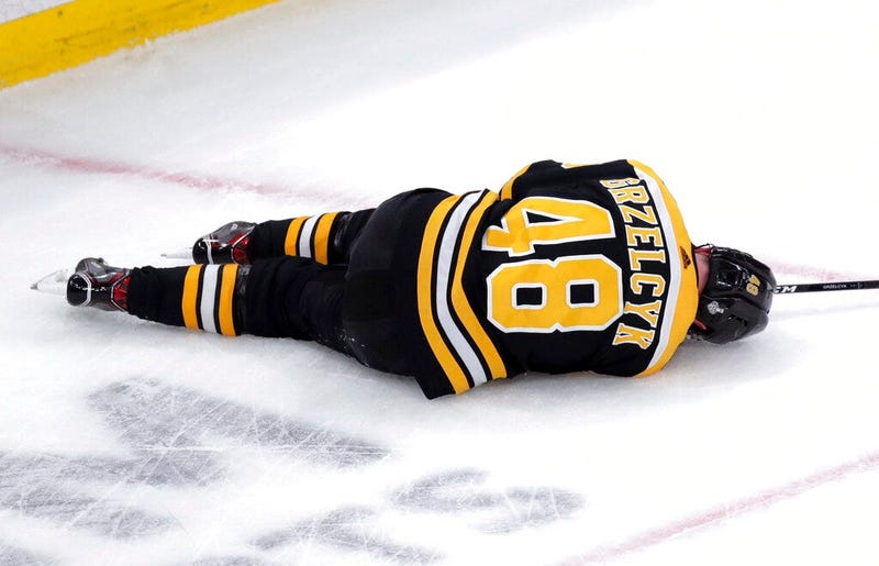Boston Bruins' Matt Grzelcyk lies injured on the ice during the first period in Game 2 of the NHL hockey Stanley Cup Final against the St. Louis Blues, Wednesday, May 29, 2019, in Boston. 